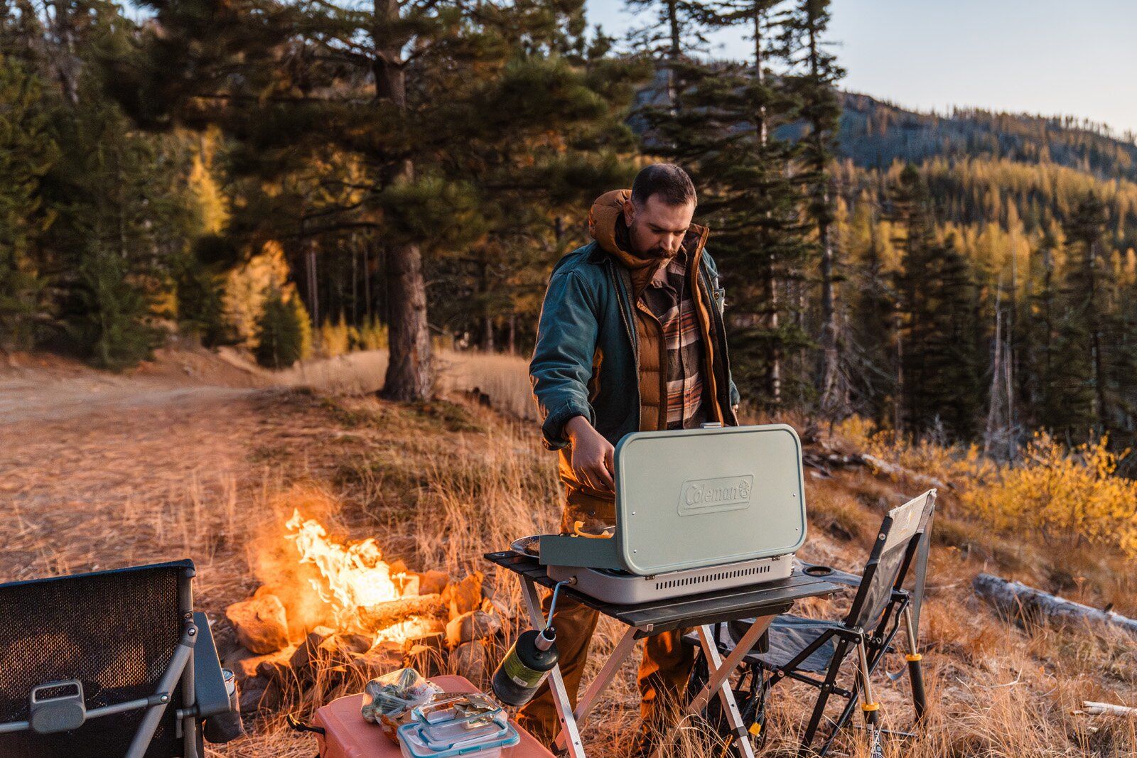 Camper cooking dinner on the Coleman Cascade 3-in-1 camping stove