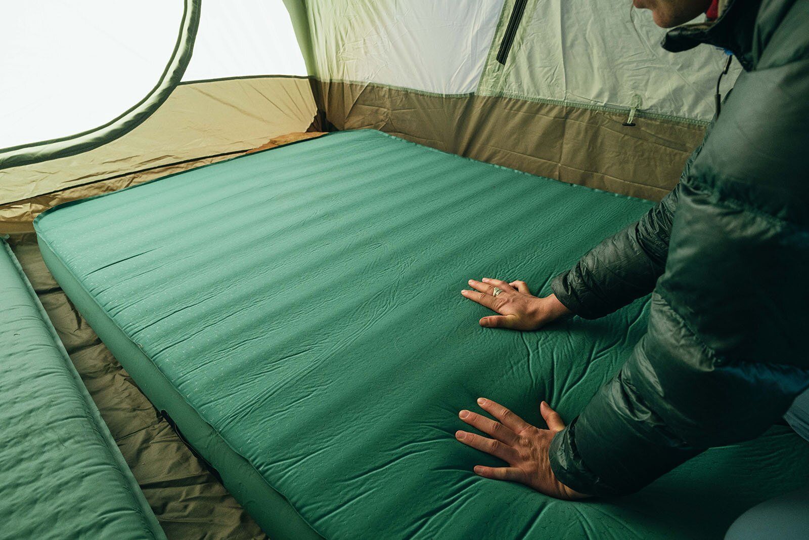 Camper pushing into the top of the Exped MegaMat Duo mattress
