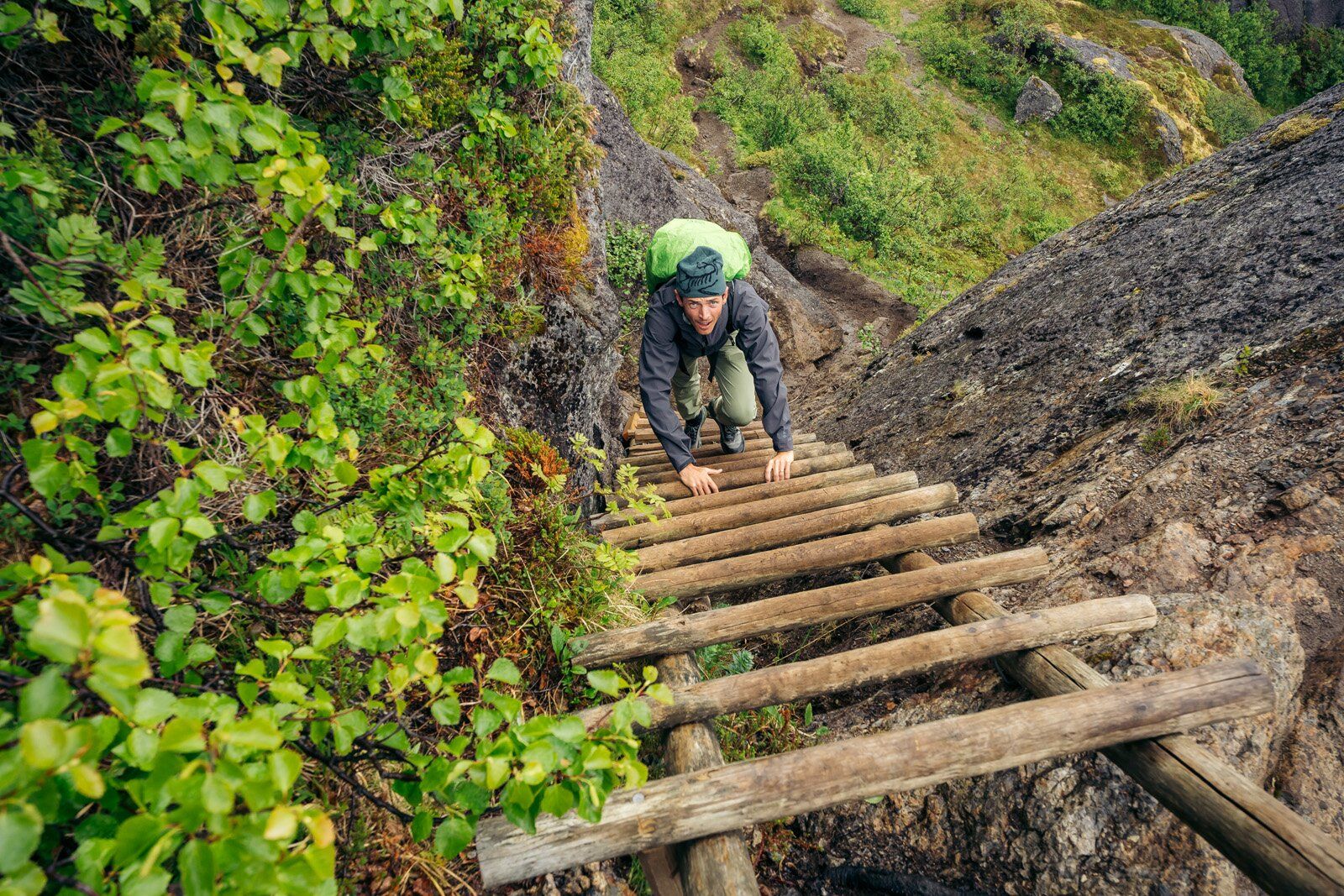Climbing ladder wearing Osprey Stratos 34 hiking daypack