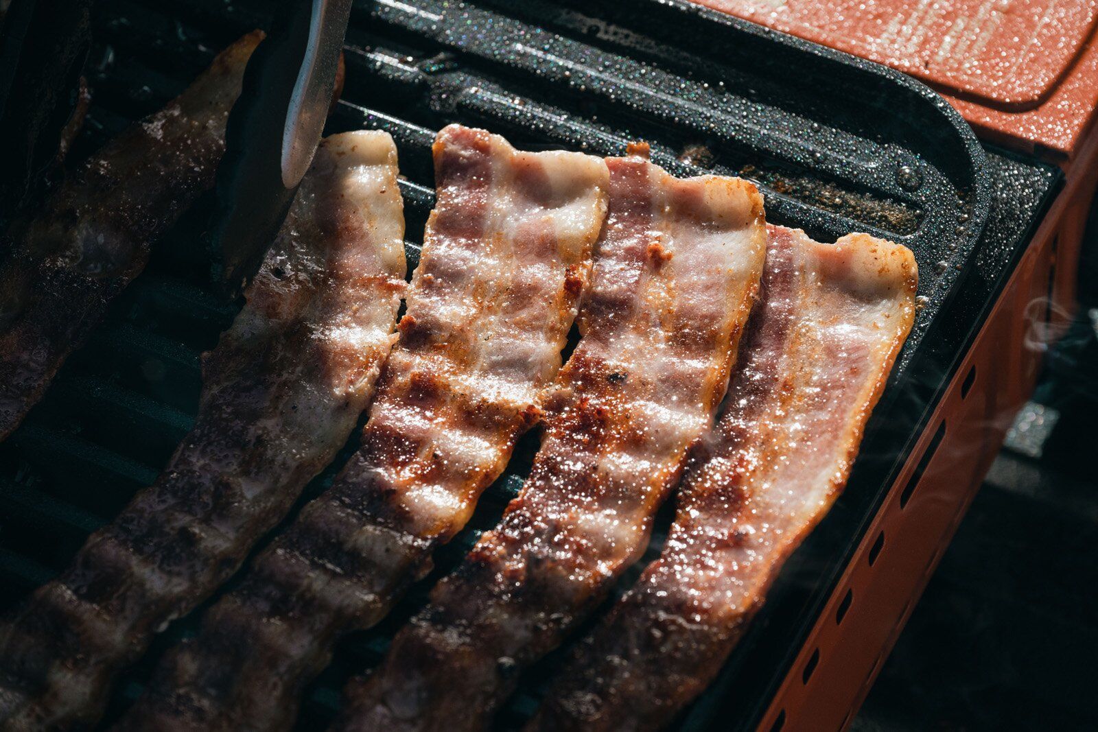 Close-up of bacon cooking on the Eureka SPRK camping stove