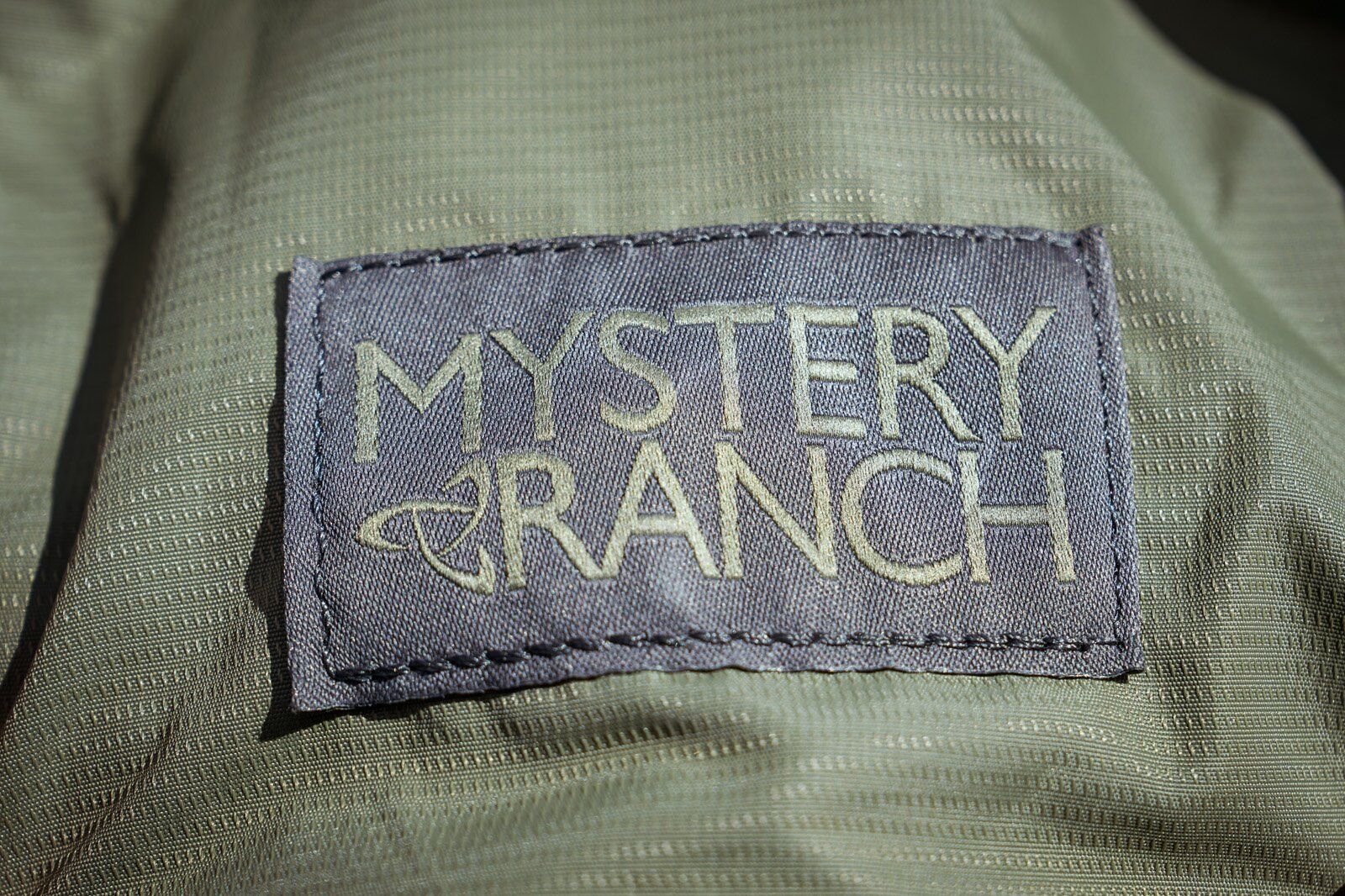 Close-up of Mystery Ranch logo on Mystery Ranch Gallagator 25 hiking daypack