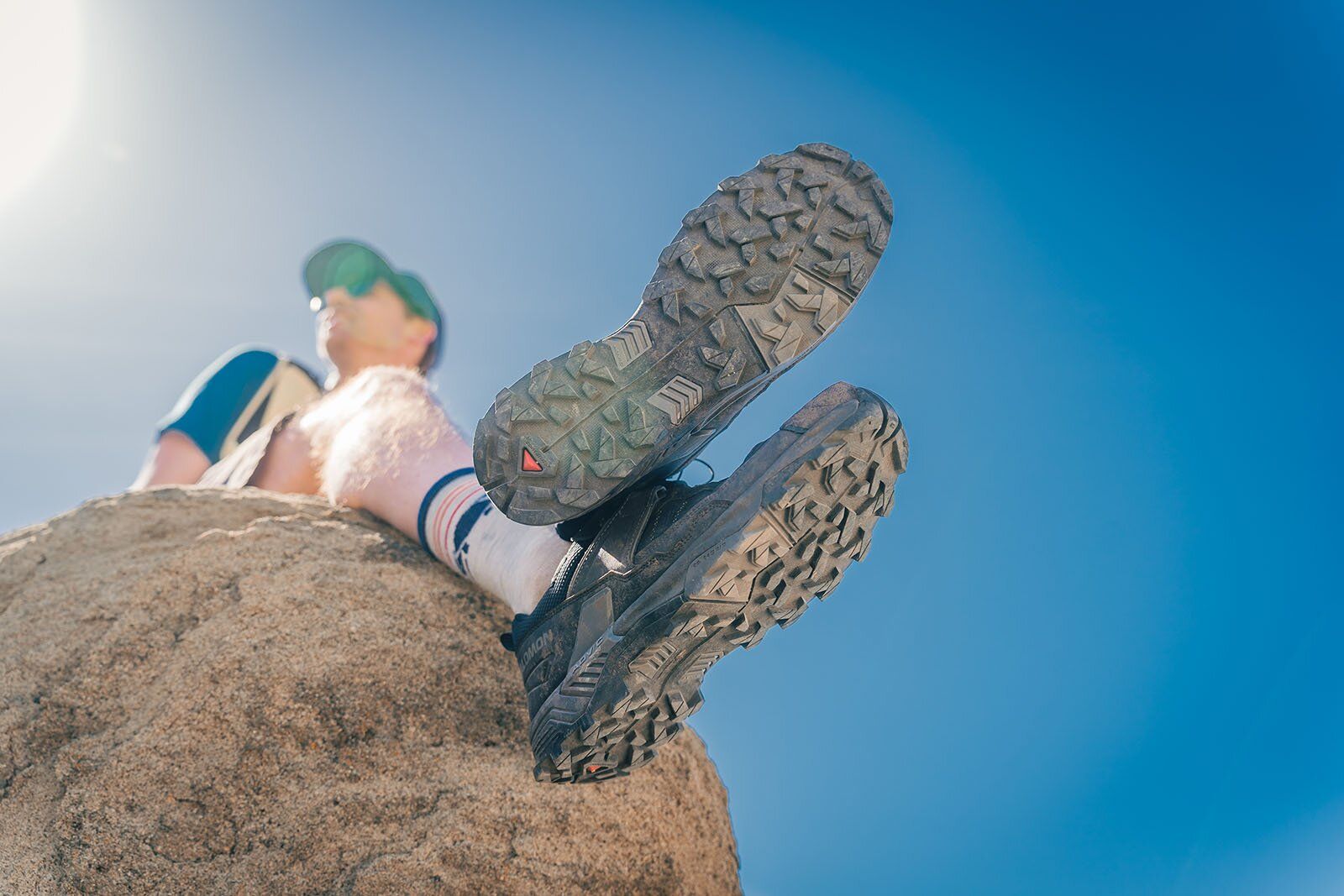 Dangling feet off rock wearing Salomon X Ultra 5 GTX hiking shoes