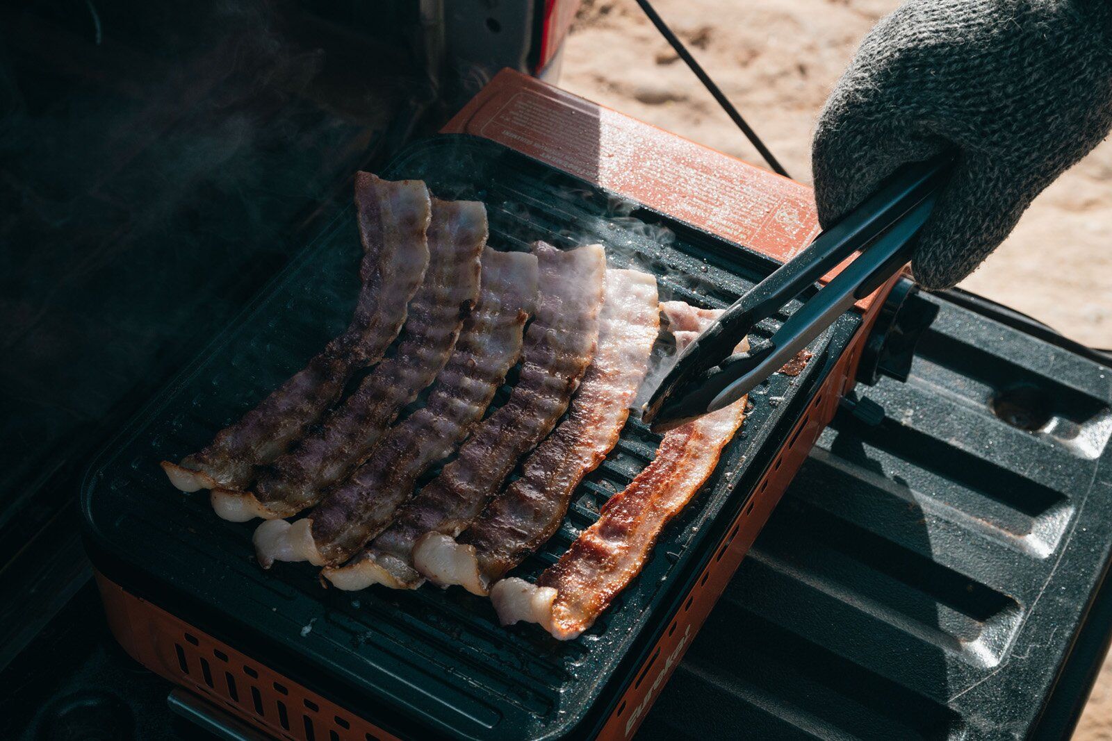Flipping bacon on the Eureka SPRK camping stove