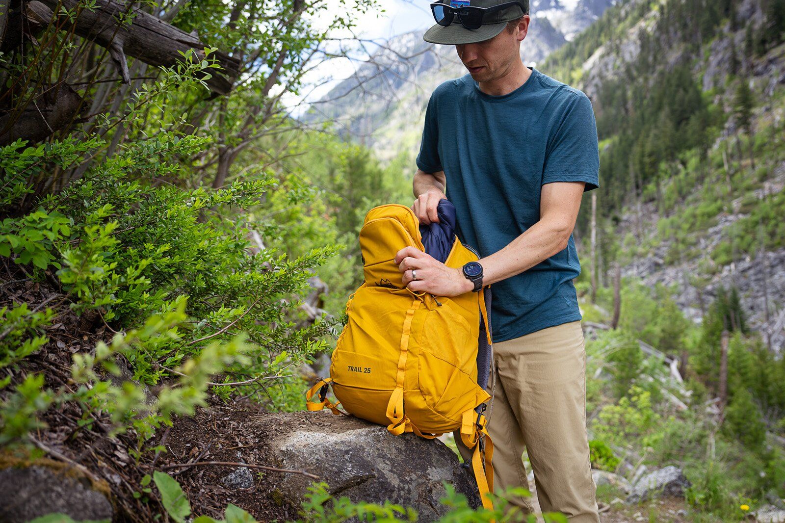 Grabbing jacket from main compartment of the REI Co-op Trail 25 hiking daypack