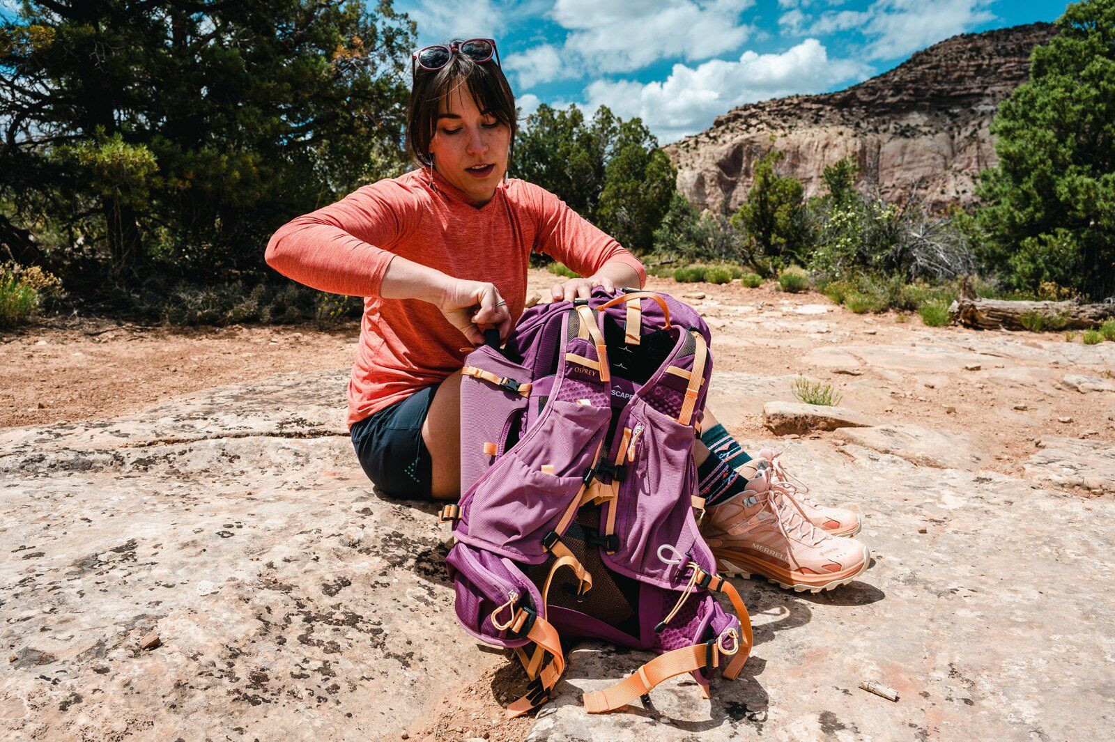 Hiker accessing side pocket of Osprey Tempest Velocity 30 hiking daypack