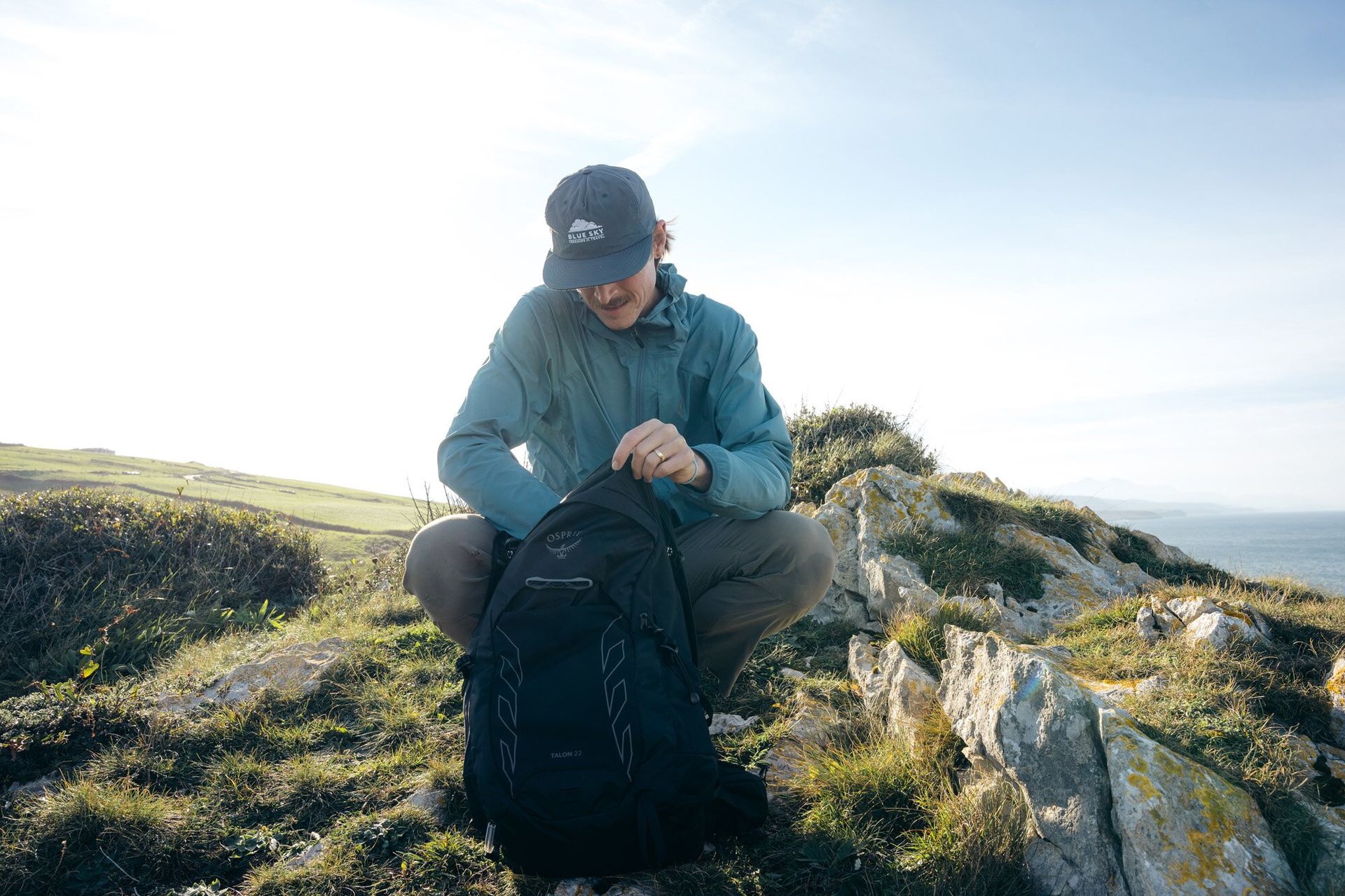 Hiker accessing the main compartment of the Osprey Talon 22 hiking daypack