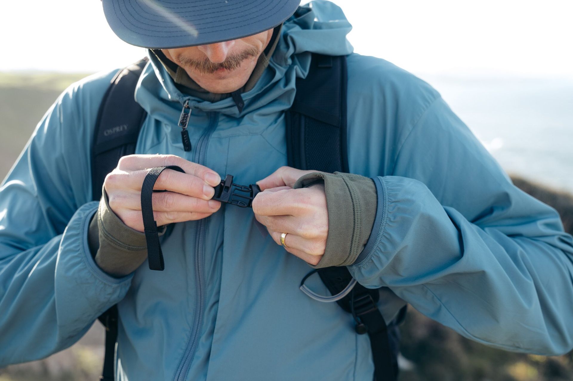 Hiker buckling chest strap of the Osprey Talon 22 hiking daypack