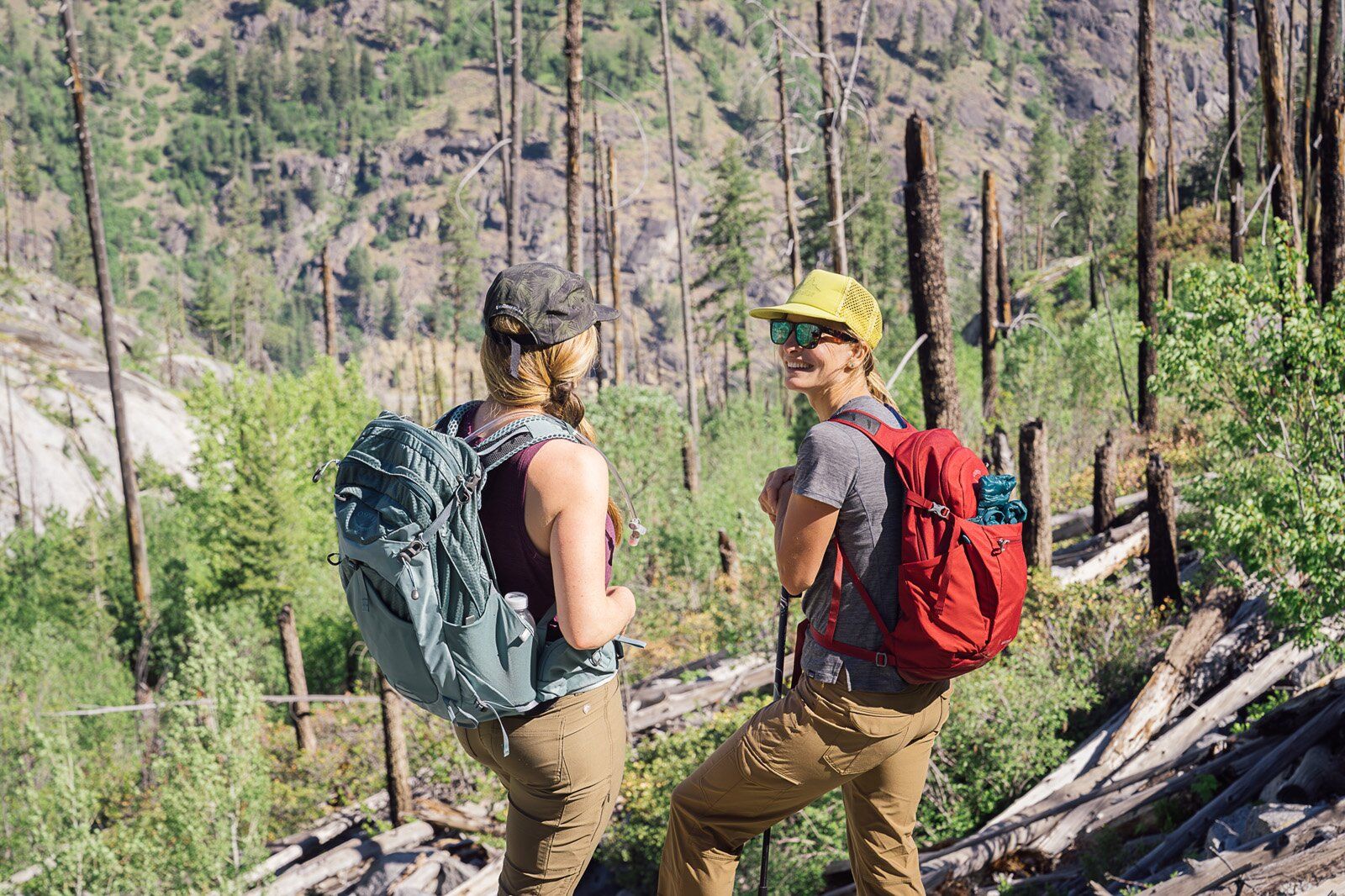 Hiker chatting with friend wearing the Osprey Mira 22 hiking daypack
