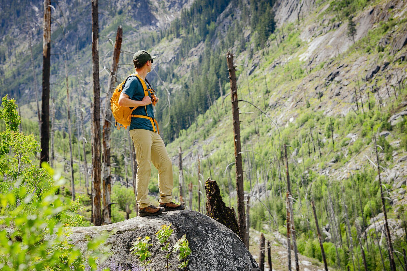 Hiker on boulder wearing the REI Co-op Trail 25 hiking daypack