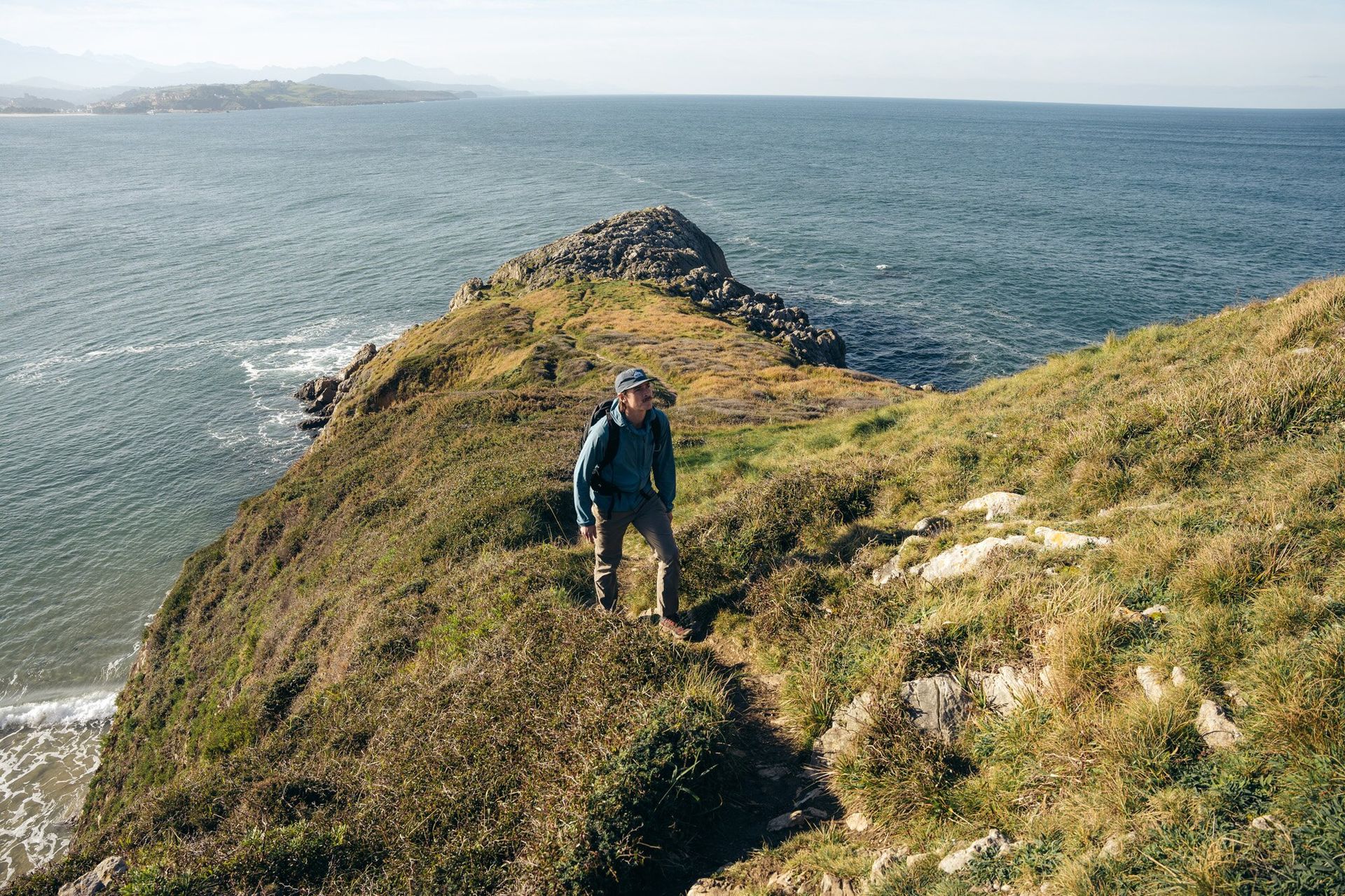 Hiker on cliff trail wearing the Osprey Talon 22 hiking daypack
