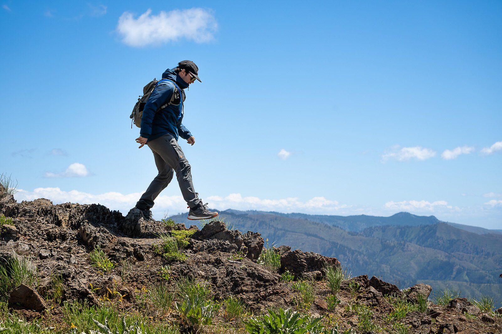 Hiker on dirt trail wearing the Mystery Ranch Gallagator 25 hiking daypack