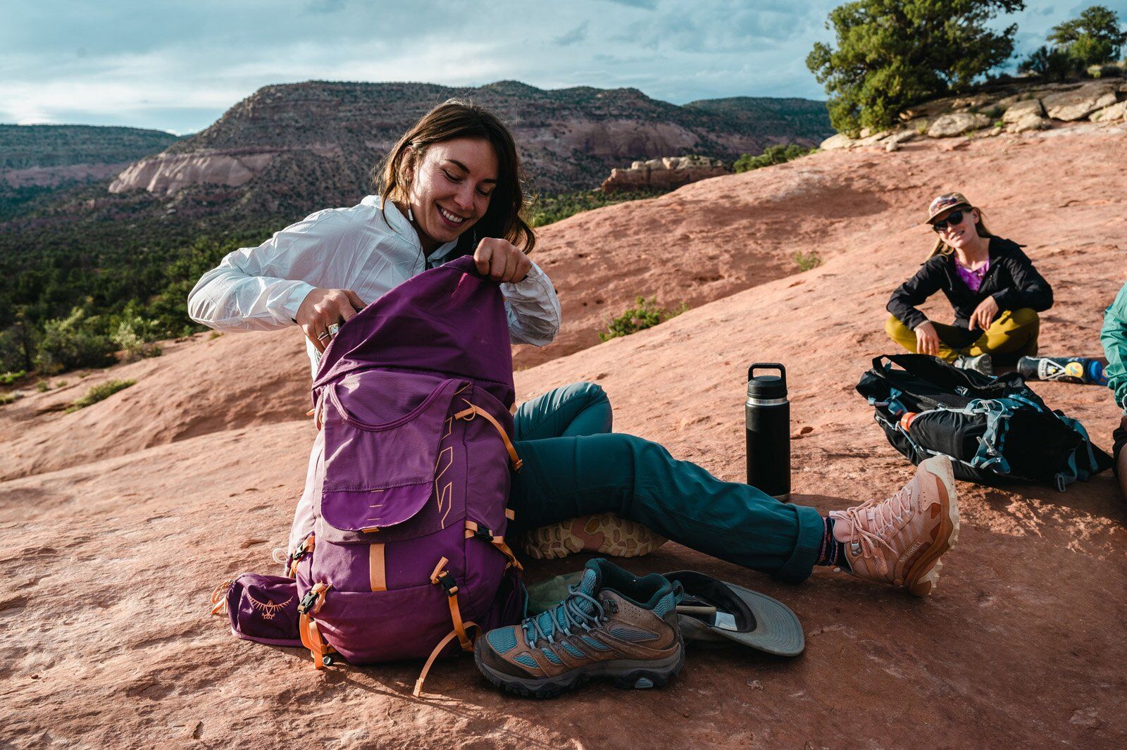 Hiker taking a break unpacking the Osprey Tempest Velocity 30 hiking daypack