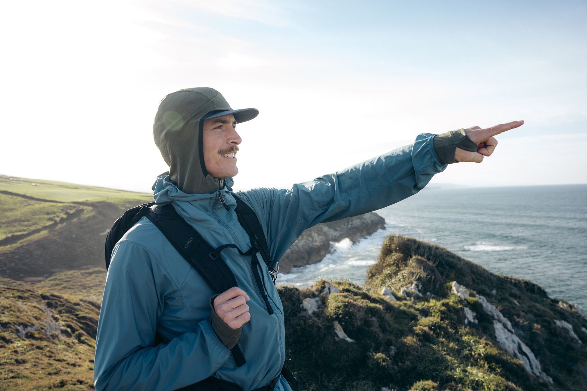 Hiker with Osprey Talon 22 hiking daypack overlooking ocean