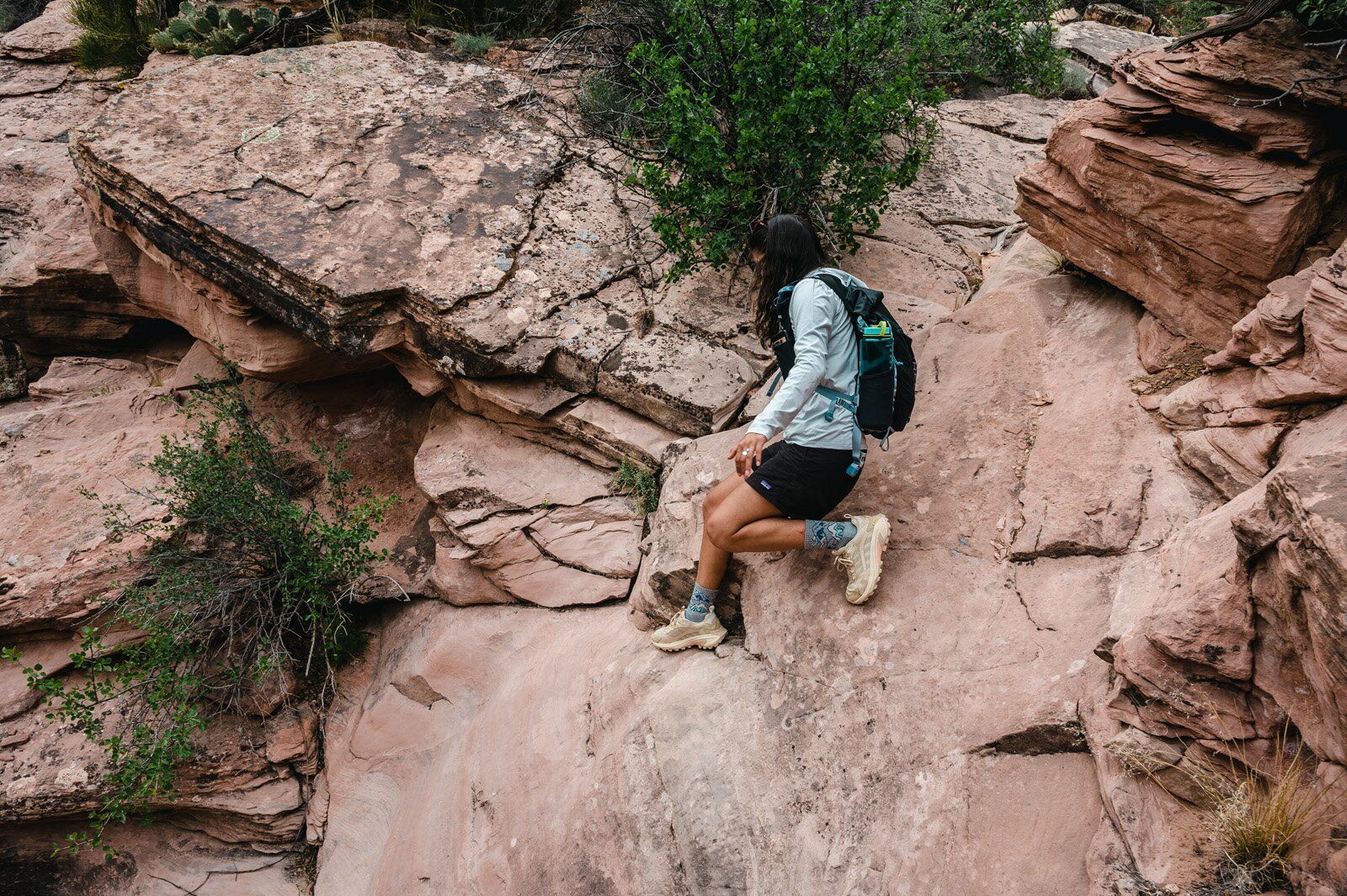 Hiking down rock trail wearing the Ultimate Direction Fastpack 20 hiking daypack