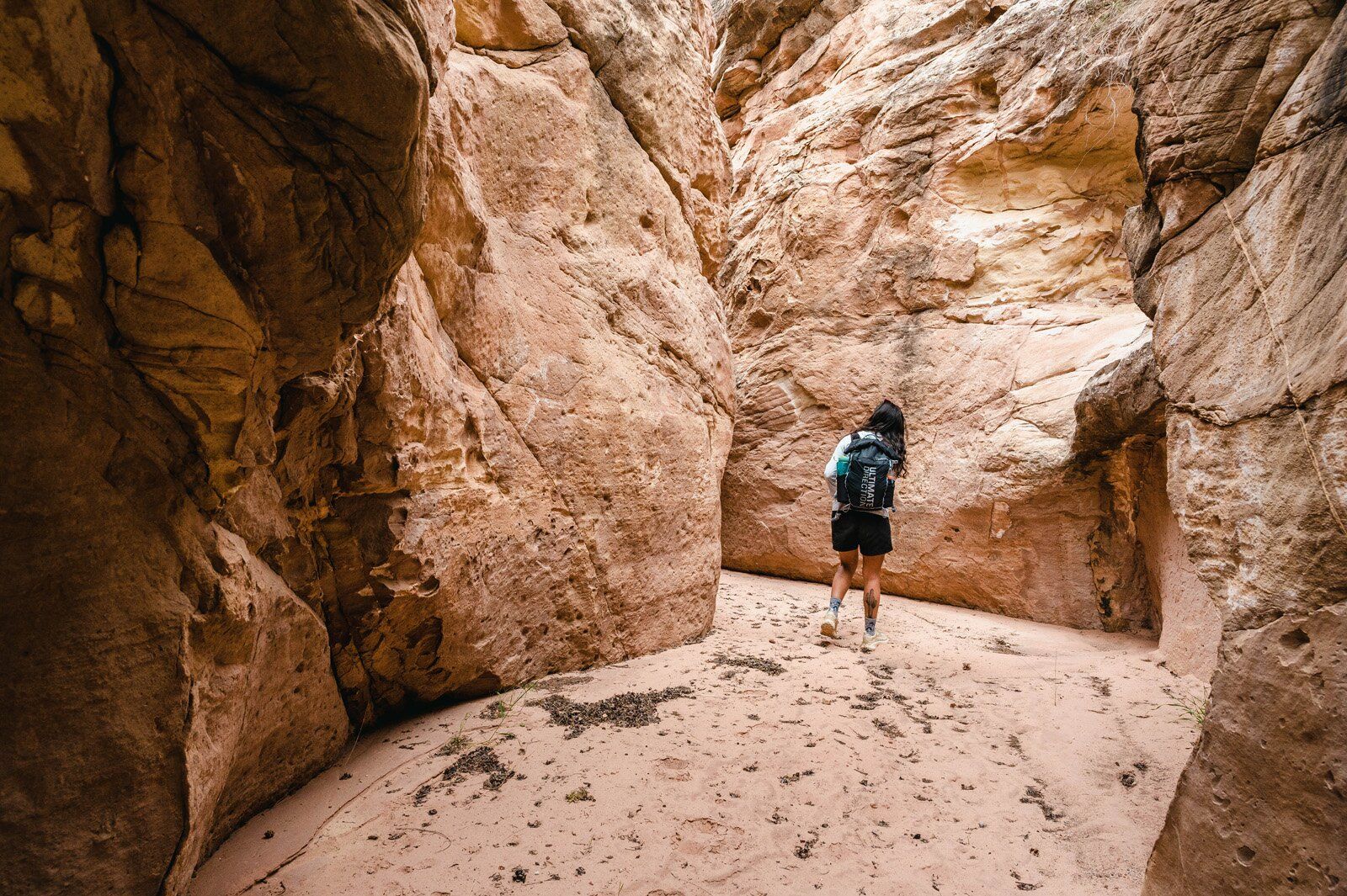 Hiking on sandy canyon trail with the Ultimate Direction Fastpack 20 hiking daypack