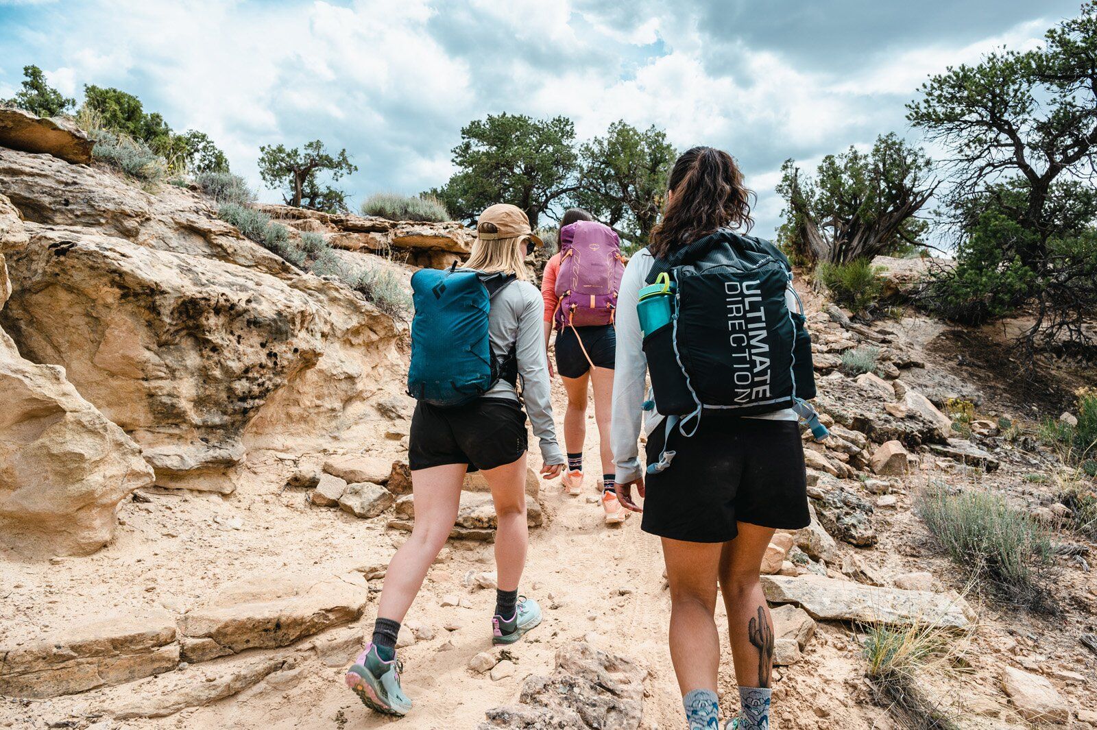 Hiking on trail wearing the Ultimate Direction Fastpack 20 hiking daypack