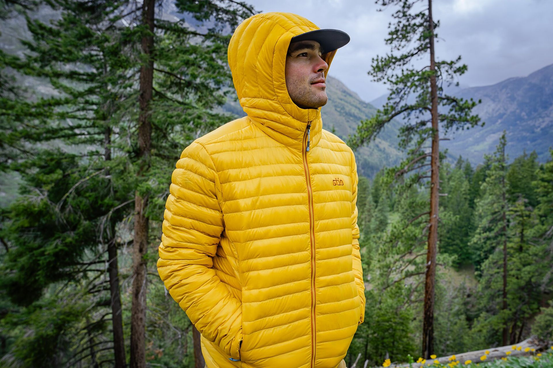 hood up, zipped up, and hands in pocket featuring the Stio Pinion Hooded Down Jacket