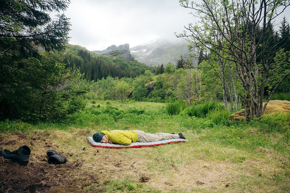 Laying on Nemo Tensor All-Season sleeping pad in lush mountains mobile