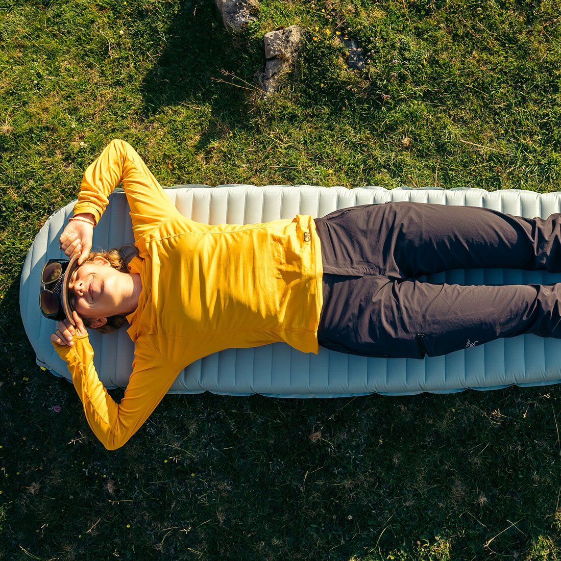 Lying on sleeping pad wearing the Outdoor Reseach Echo Hoody base layer