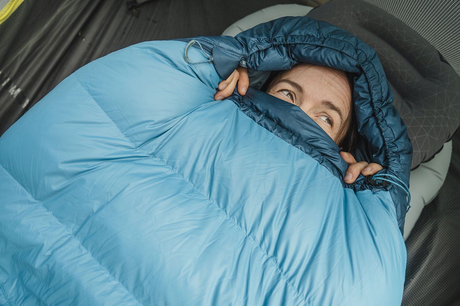 Lying on sleeping pad wearing the Outdoor Reseach Echo Hoody base layer