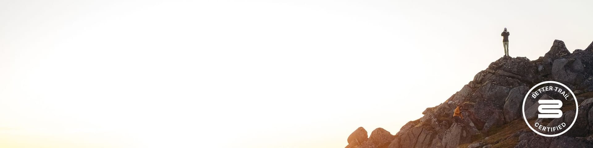 Man on ridgeline in mountains at sunset