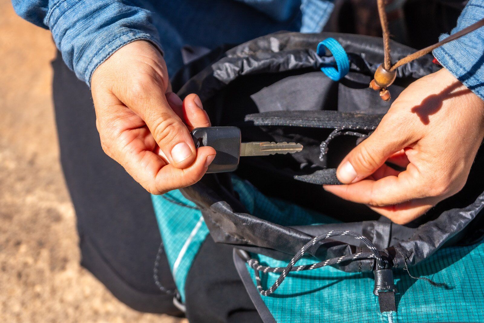 Placing key in small zipper pocket in the Black Diamond Distance 22 hiking daypack