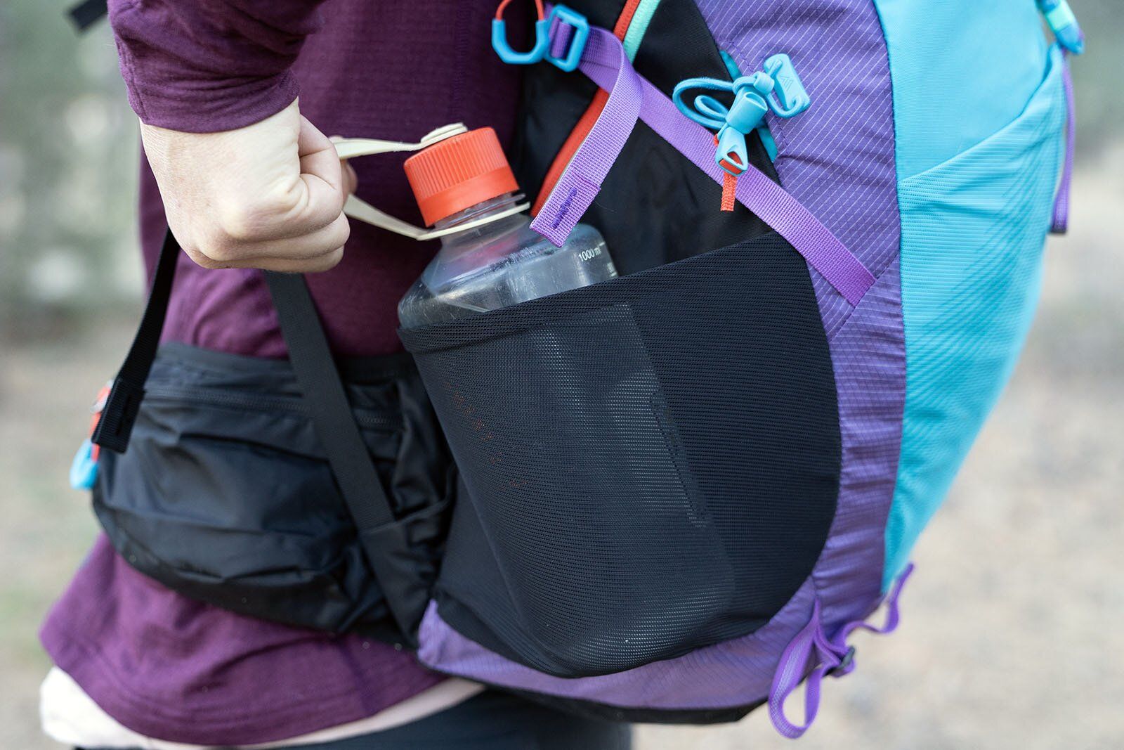 Pulling water bottle from side pocket of Gregory Maya 20 hiking daypack