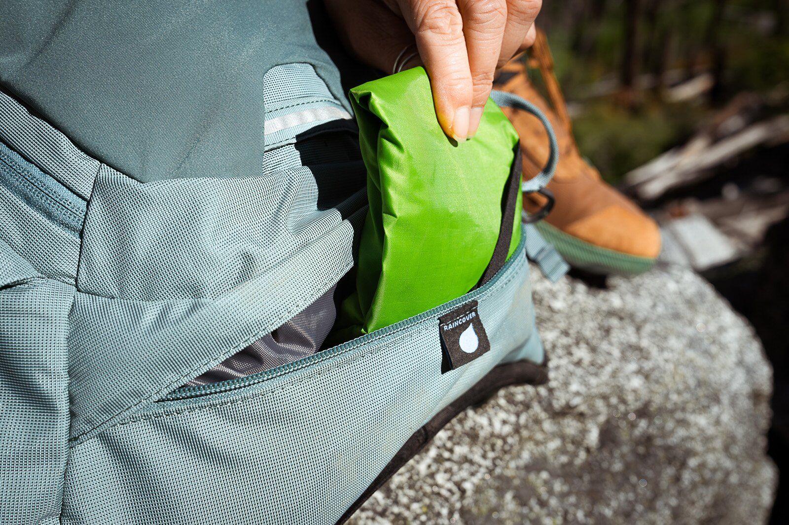 Raincover stored in zipper pocket of Osprey Mira 22 hiking daypack