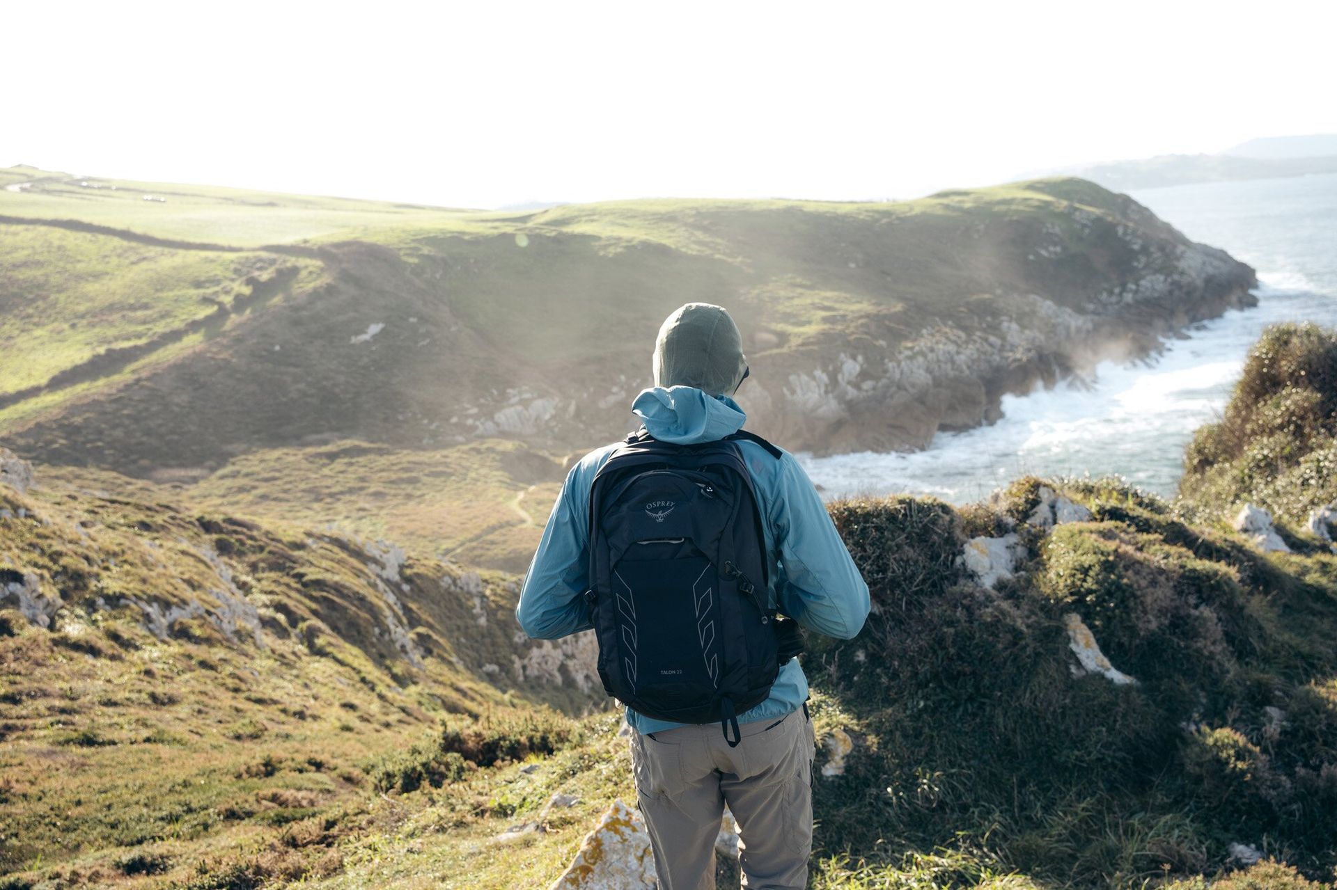 Rear view of hiker on trail wearing the Osprey Talon 22 hiking daypack