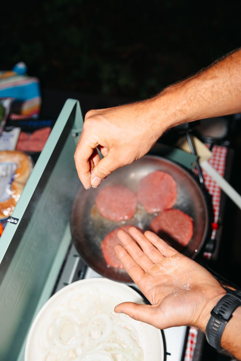 Salting onions while they cook on the Coleman Cascade Classic camping stove