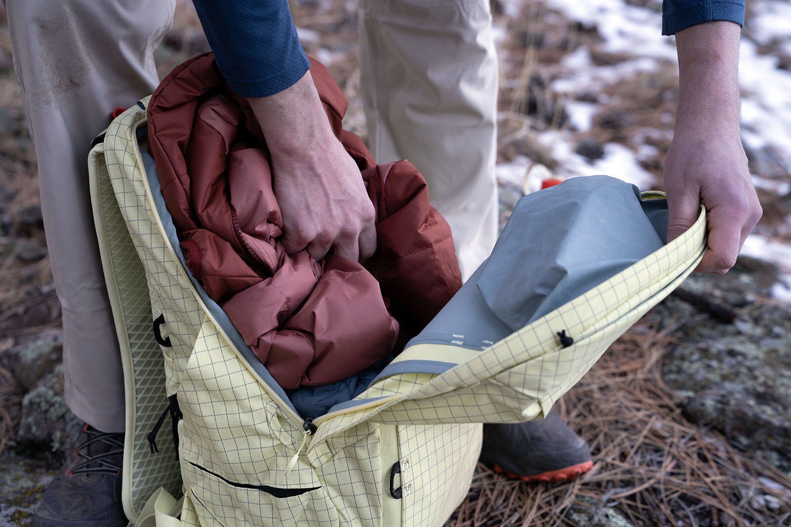 Shoving jacket into  Nemo Resolve Endless Promise 25 hiking daypack