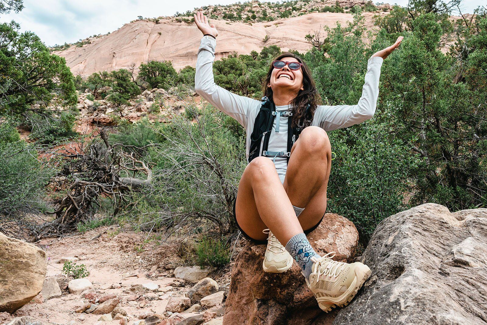 Sitting on rock wearing Merrell Moab Speed 2 hiking shoe