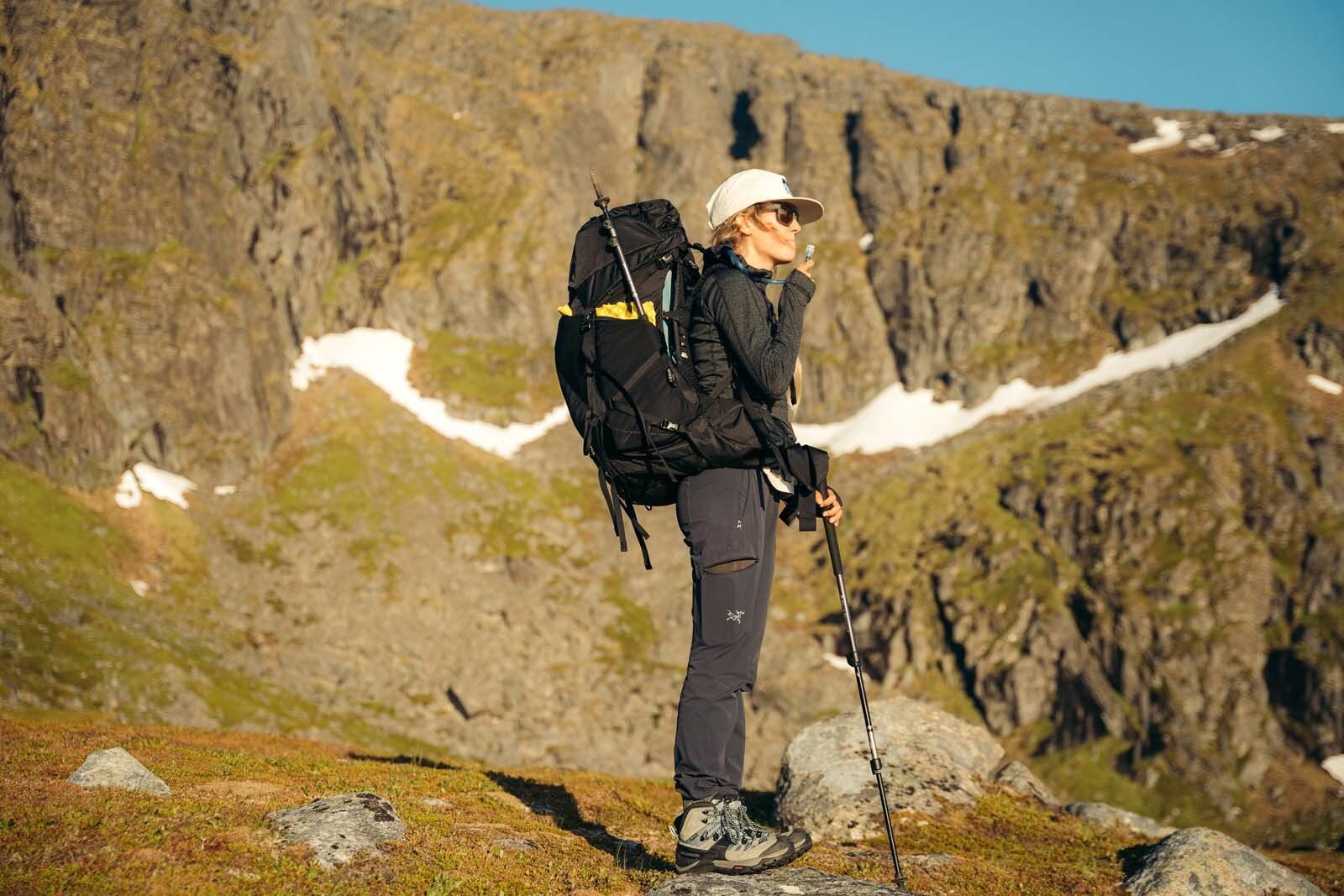 Taking a sip of water from a hydration pack in the Osprey Aura - Atmos LT 50 Backpack