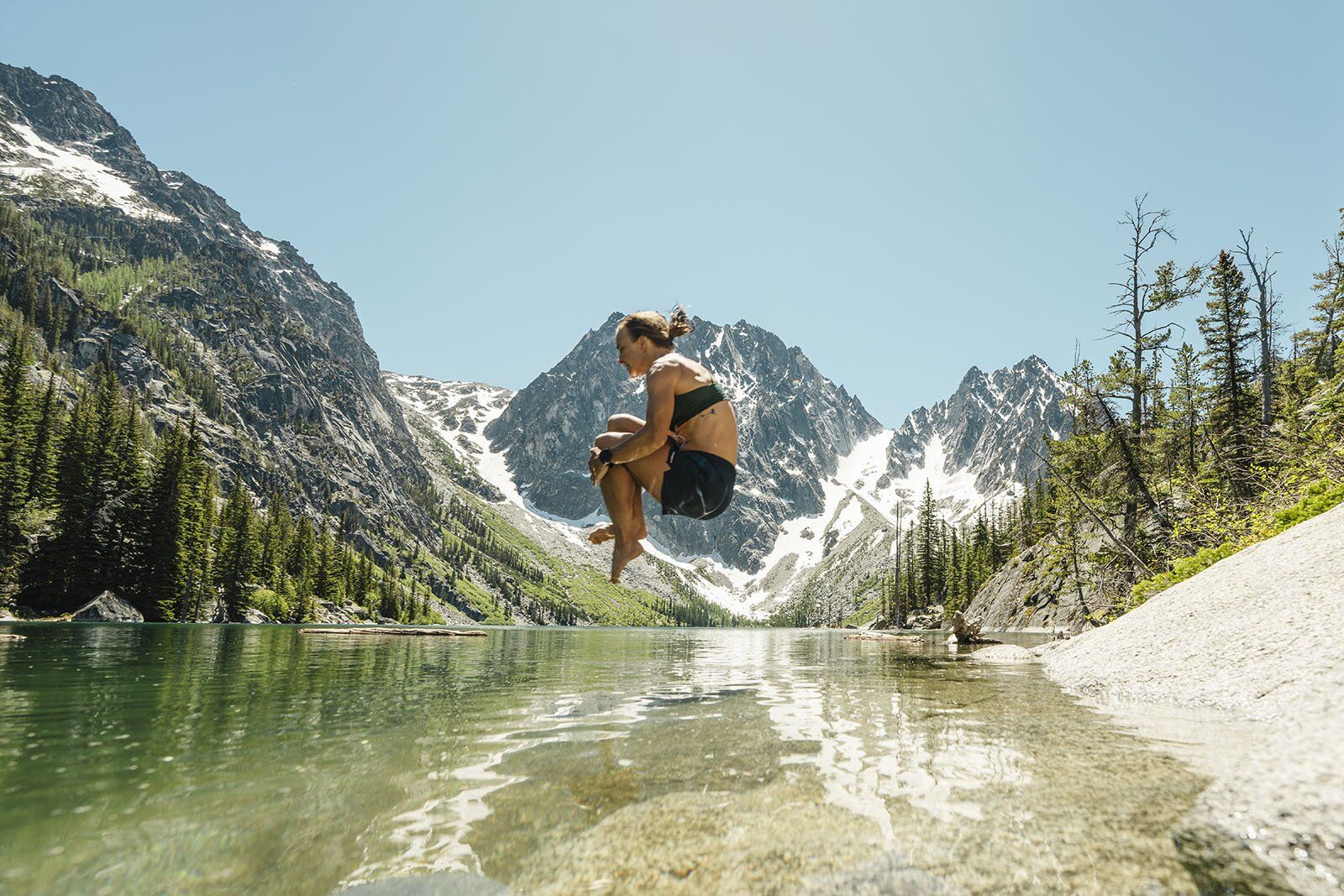 Three human shadows on sandstone wall overlooking deep river canyon