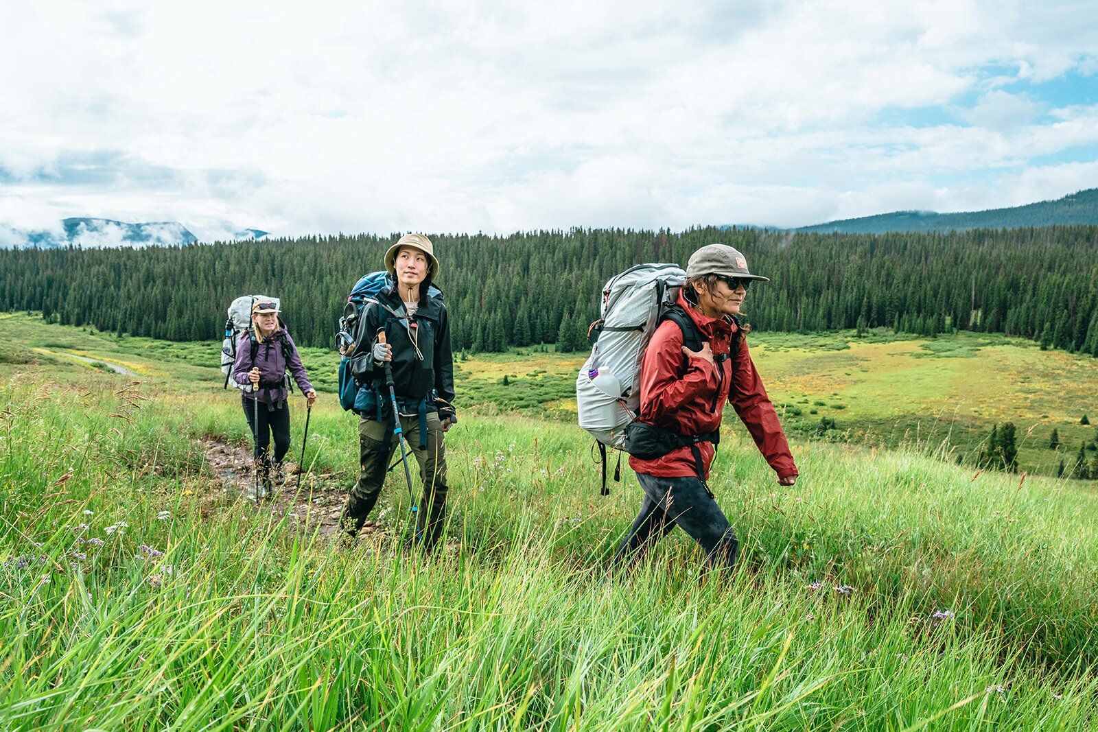 Three women backpacking in tall grass.jpg