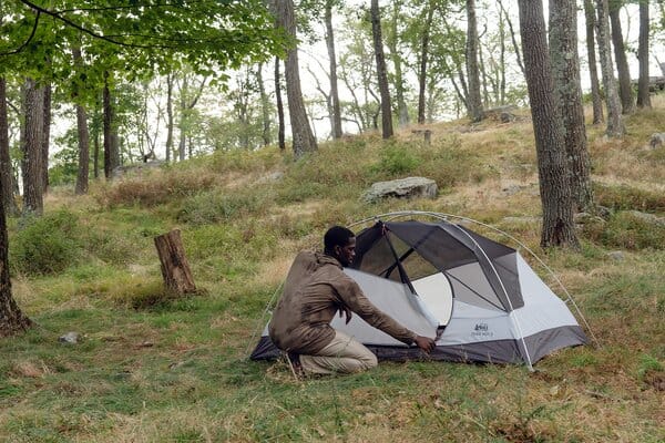 Unzipping door of REI Co-op Trail Hut 2 backpacking tent in forest