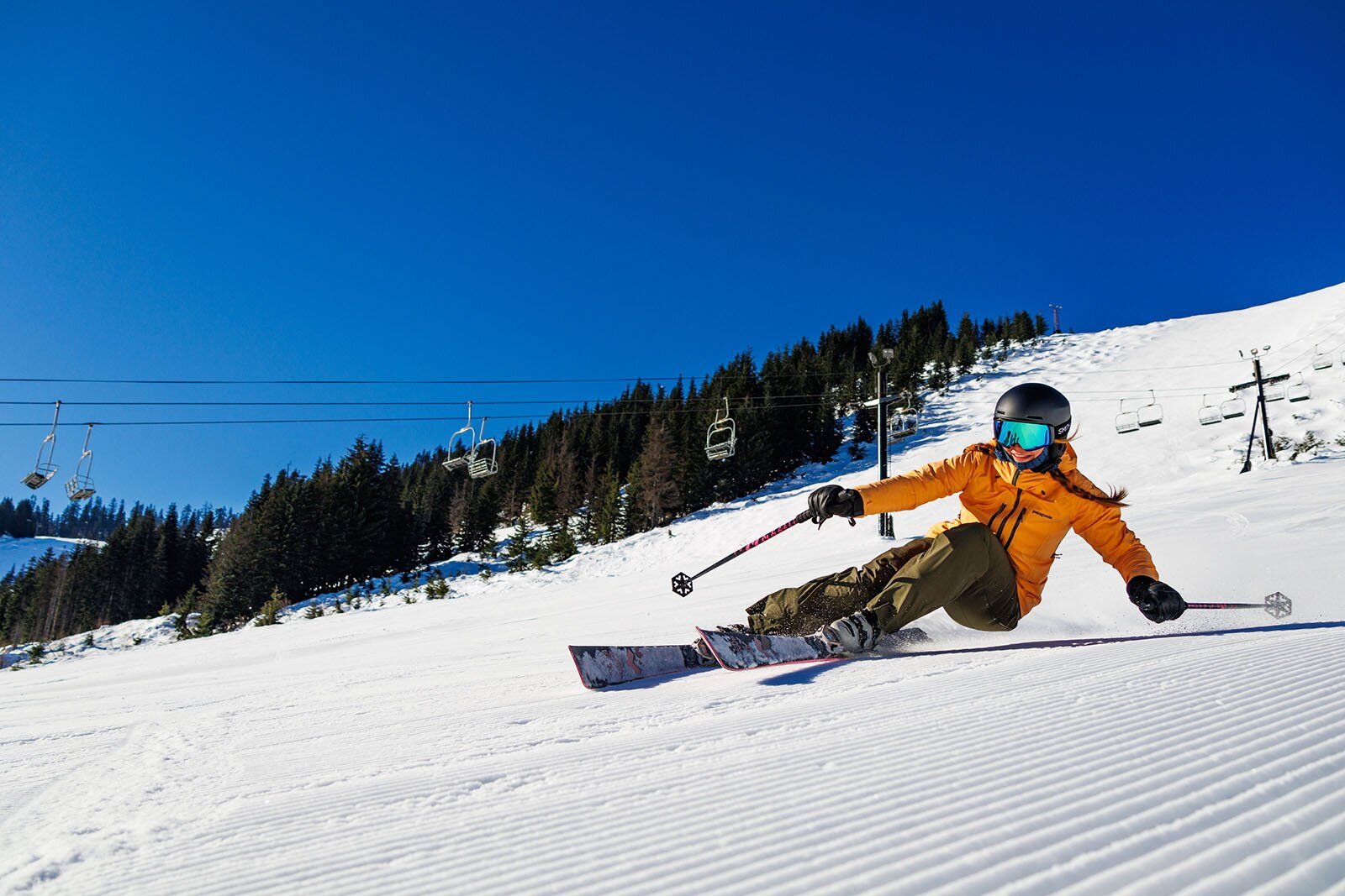 Vivika carving low on a groomer