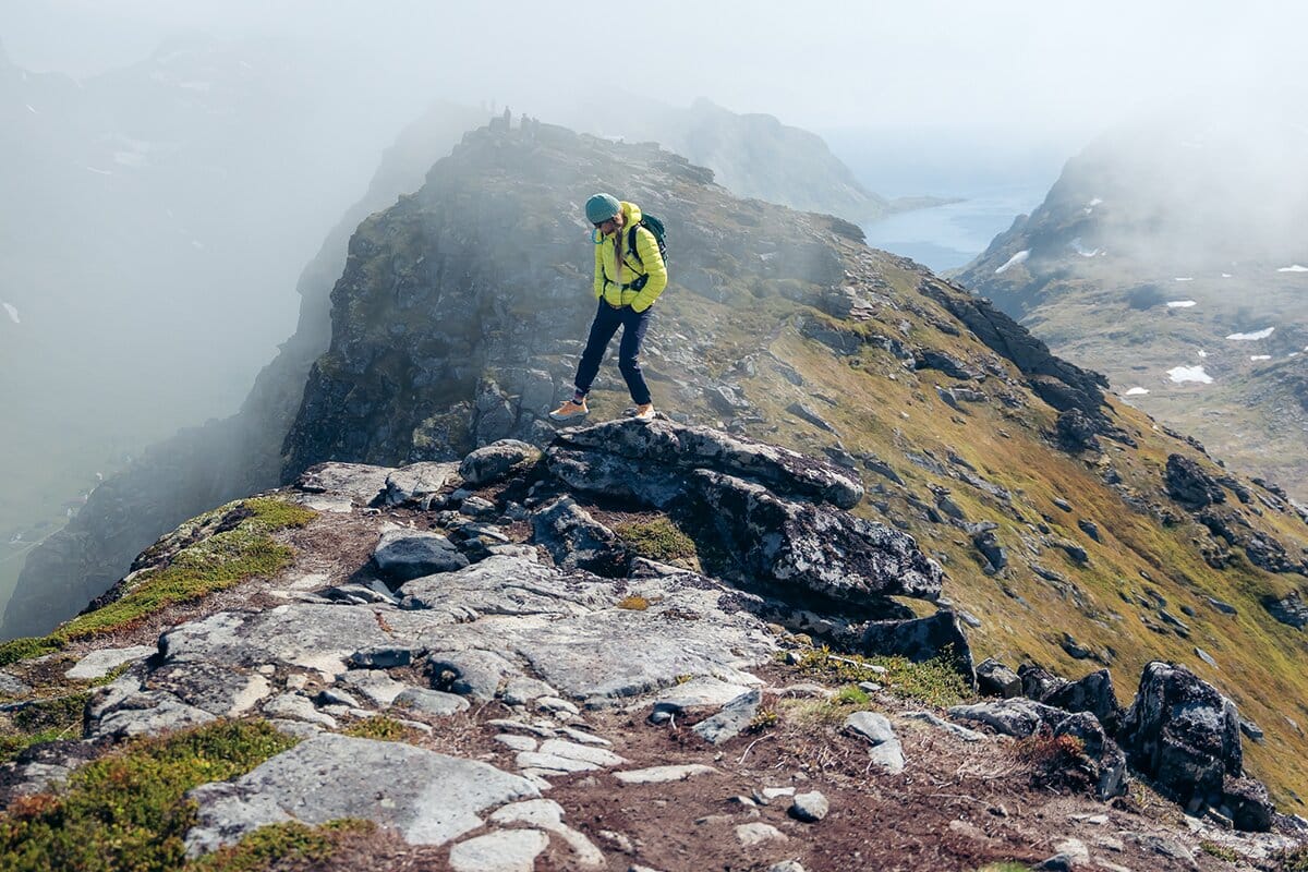 Walking down rocky trail in Lofoten in Saucony Peregrine hiking shoes mobile