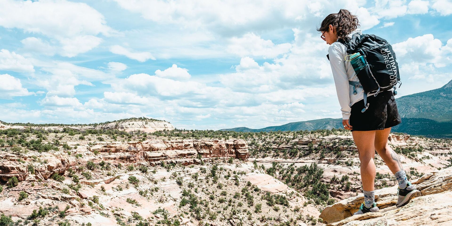 Woman looking down over desert chasm