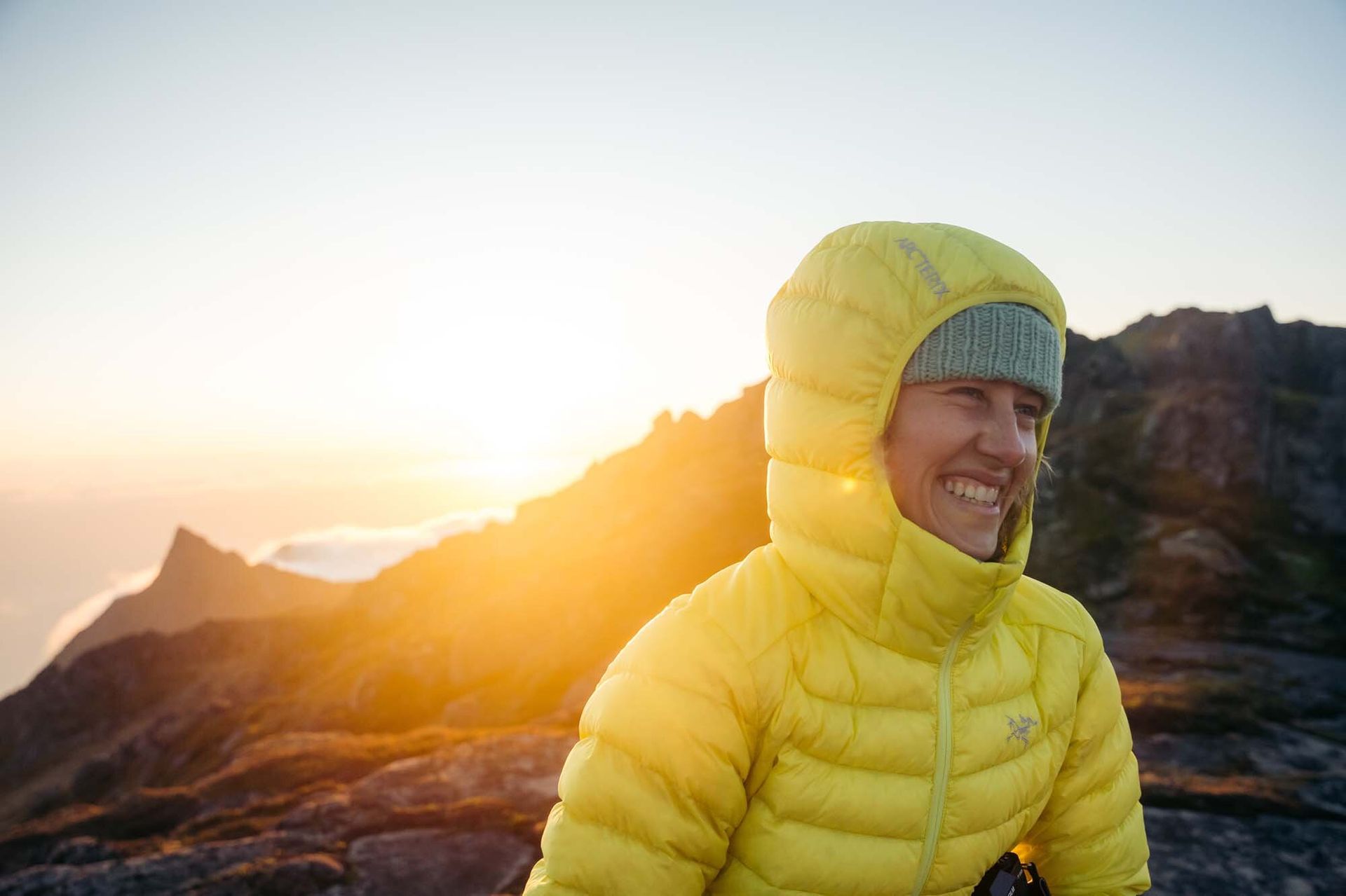Woman smiling wearing Arc'teryx Cerium Hoody down jacket
